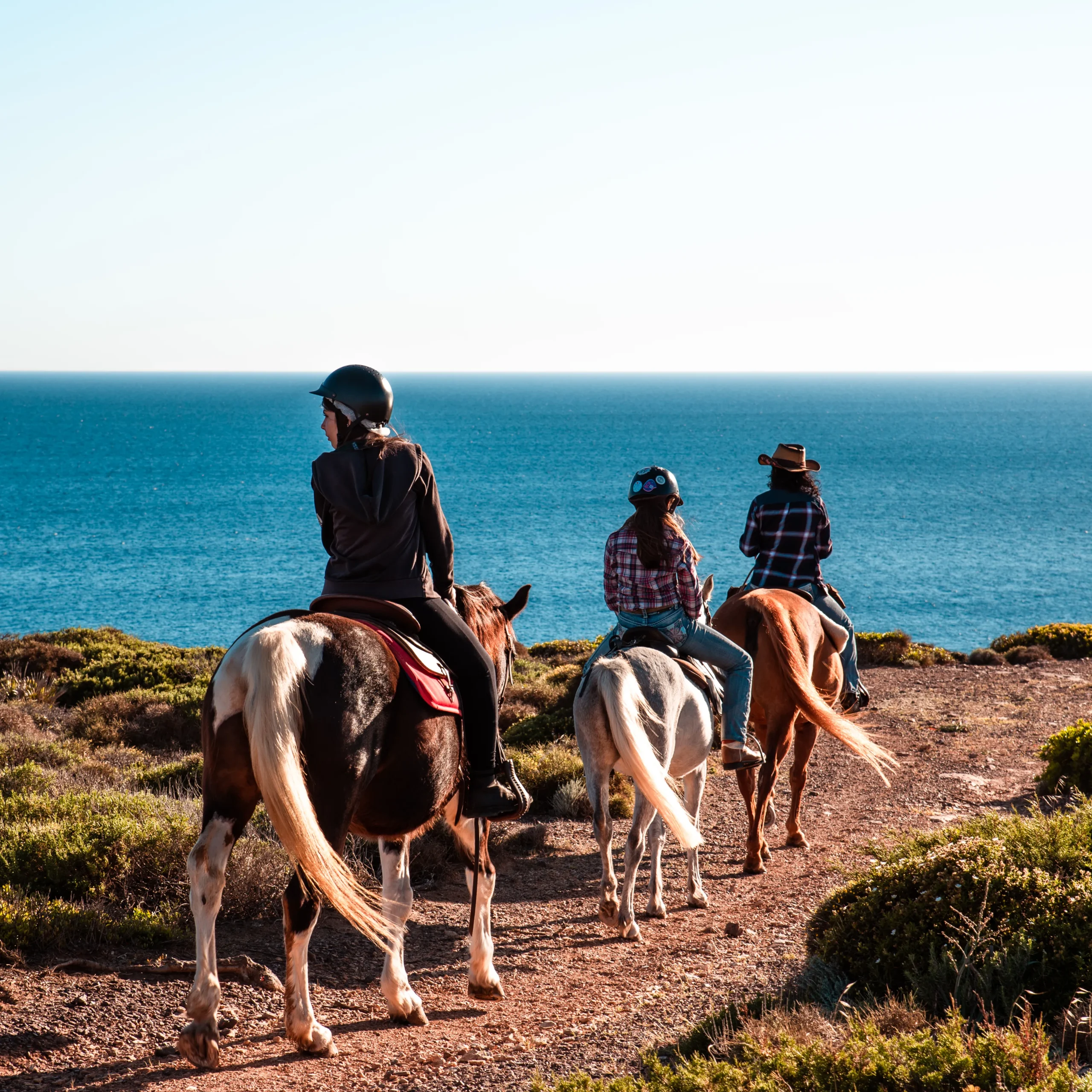 Cavaliers en selle western sur le sentier côtier de Sant'Antioco, face à la mer de Sardaigne
